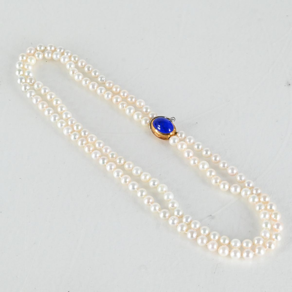 Ole Lynggaard, collierlås, 18K Guld med Lapis Lazuli och diamant 0,08 ct. samt 2 st pärlcollier, odlade pärlor på auktion i Luleå, Norrbottens län hos Luleå Auktionsverk